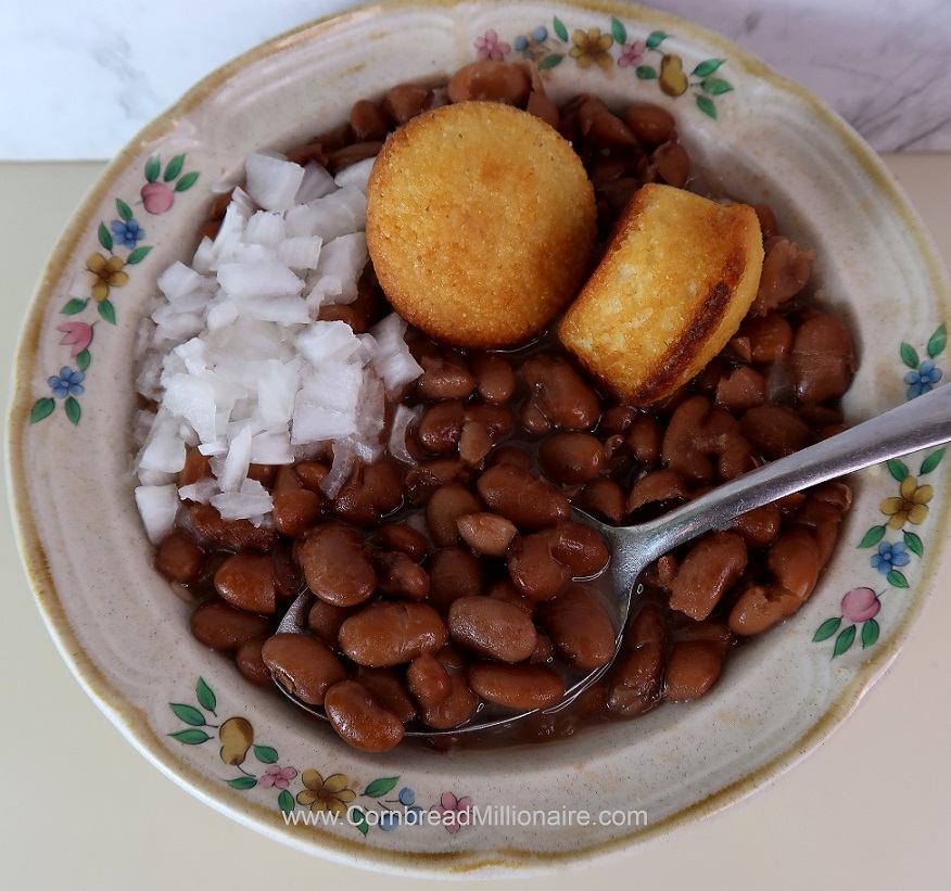 Southern Pinto Beans served with chopped onions and cornbread muffins.