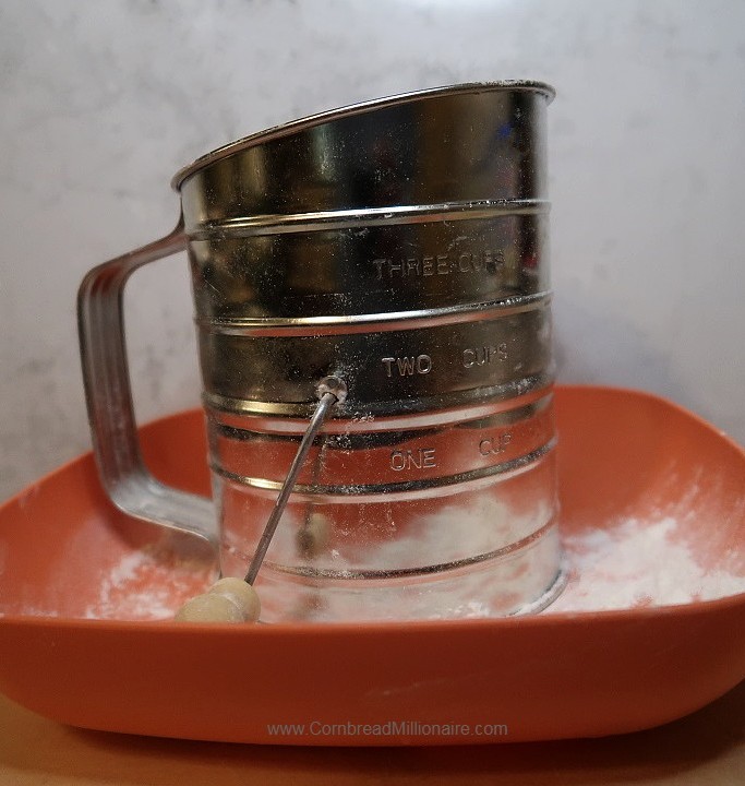 Homemade Self-Rising Flour in a hand-crank sifter.